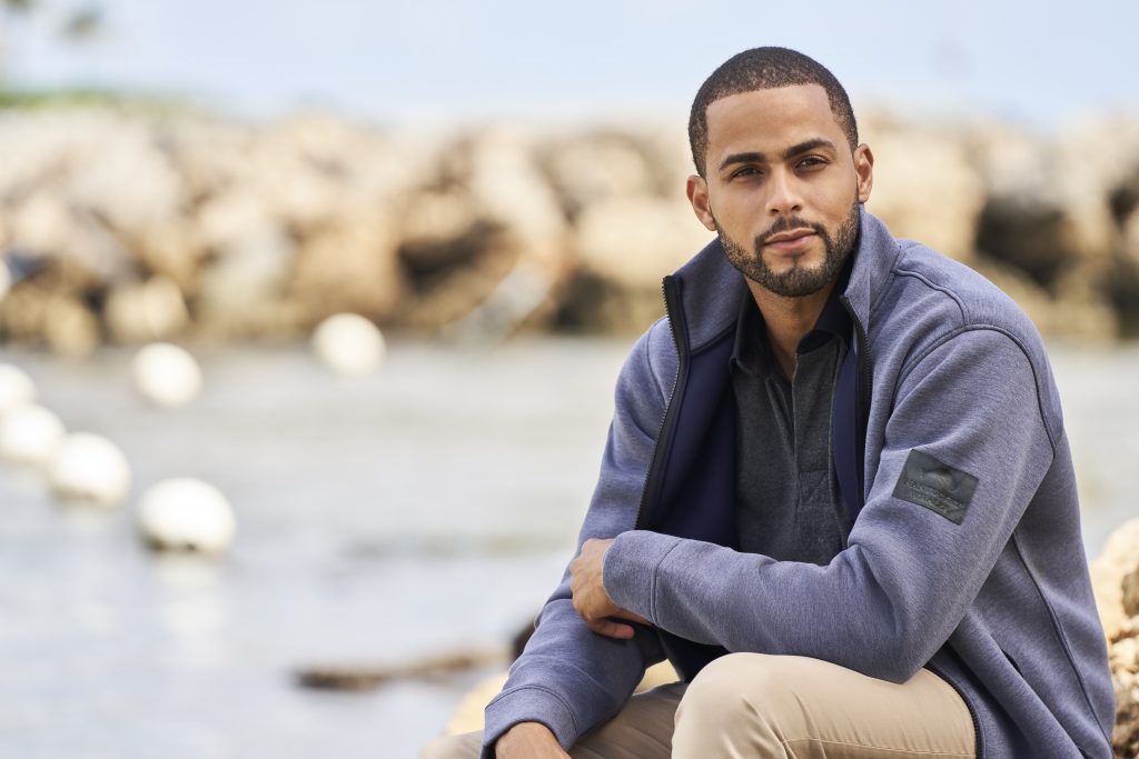 Male model wearing a blue zip up jacket.