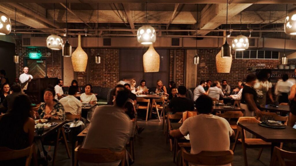 A bustling restaurant interior filled with patrons, featuring modern decor and inviting lighting that enhances the vibrant atmosphere.