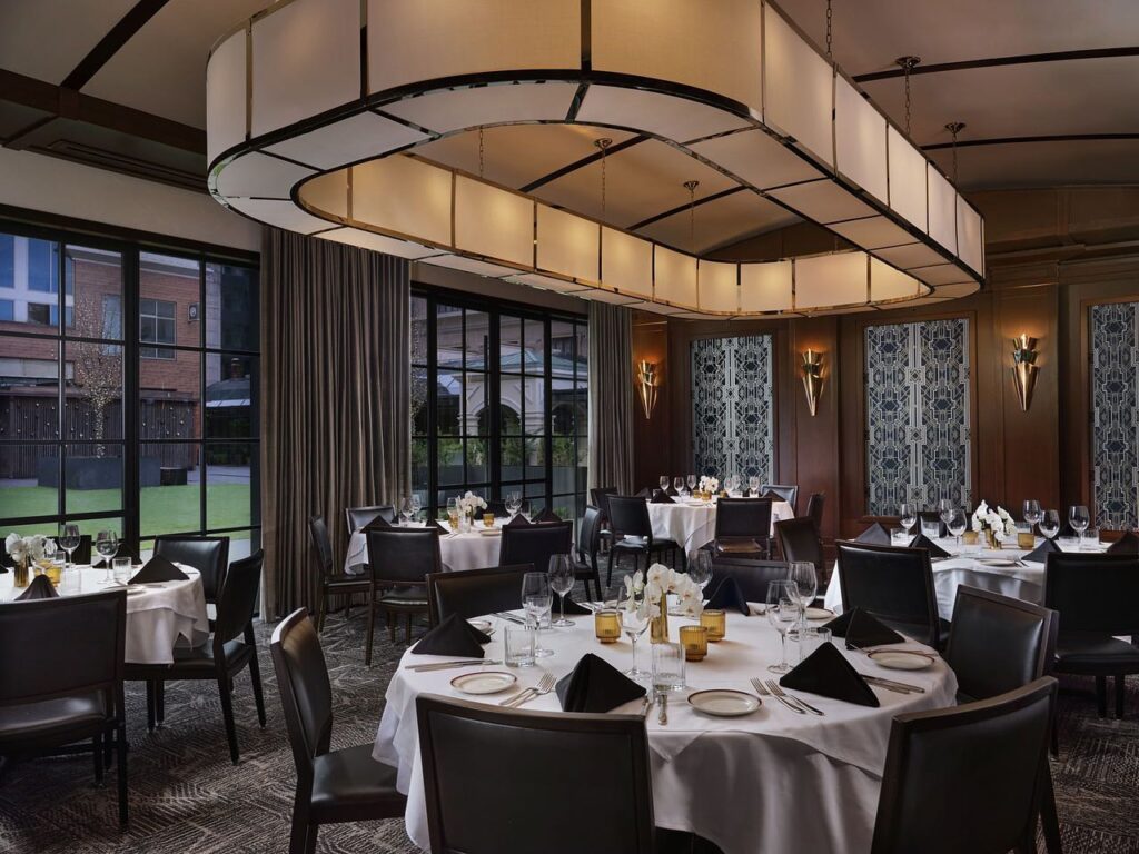 A photograph depicting the luxurious interior of a high-end steakhouse, characterized by its exquisite ambiance. The setting features opulent furnishings, elegant table settings, and ambient lighting