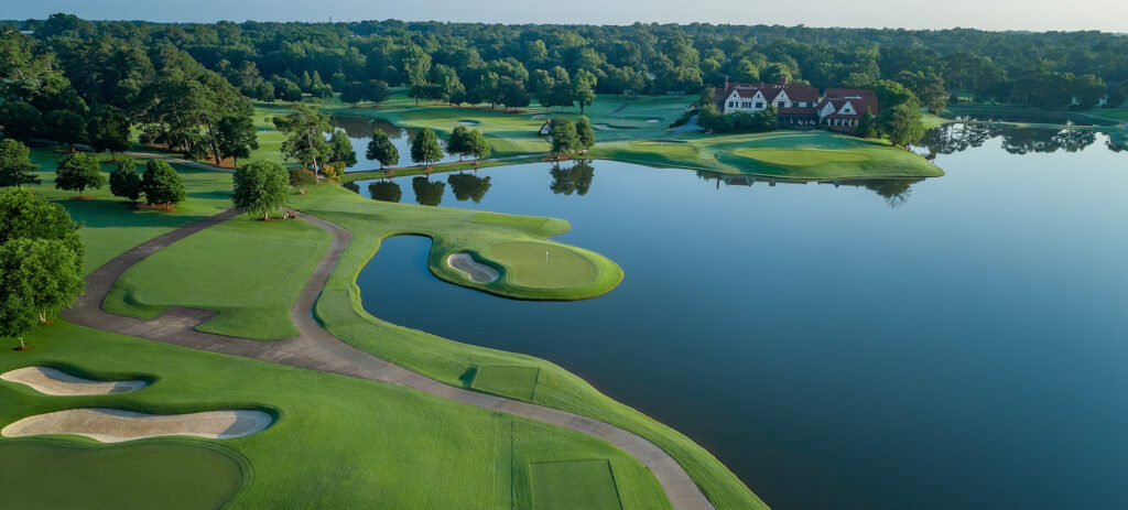An image showcasing a high-end golf course with a luxurious resort nestled by the side of a beautiful lake