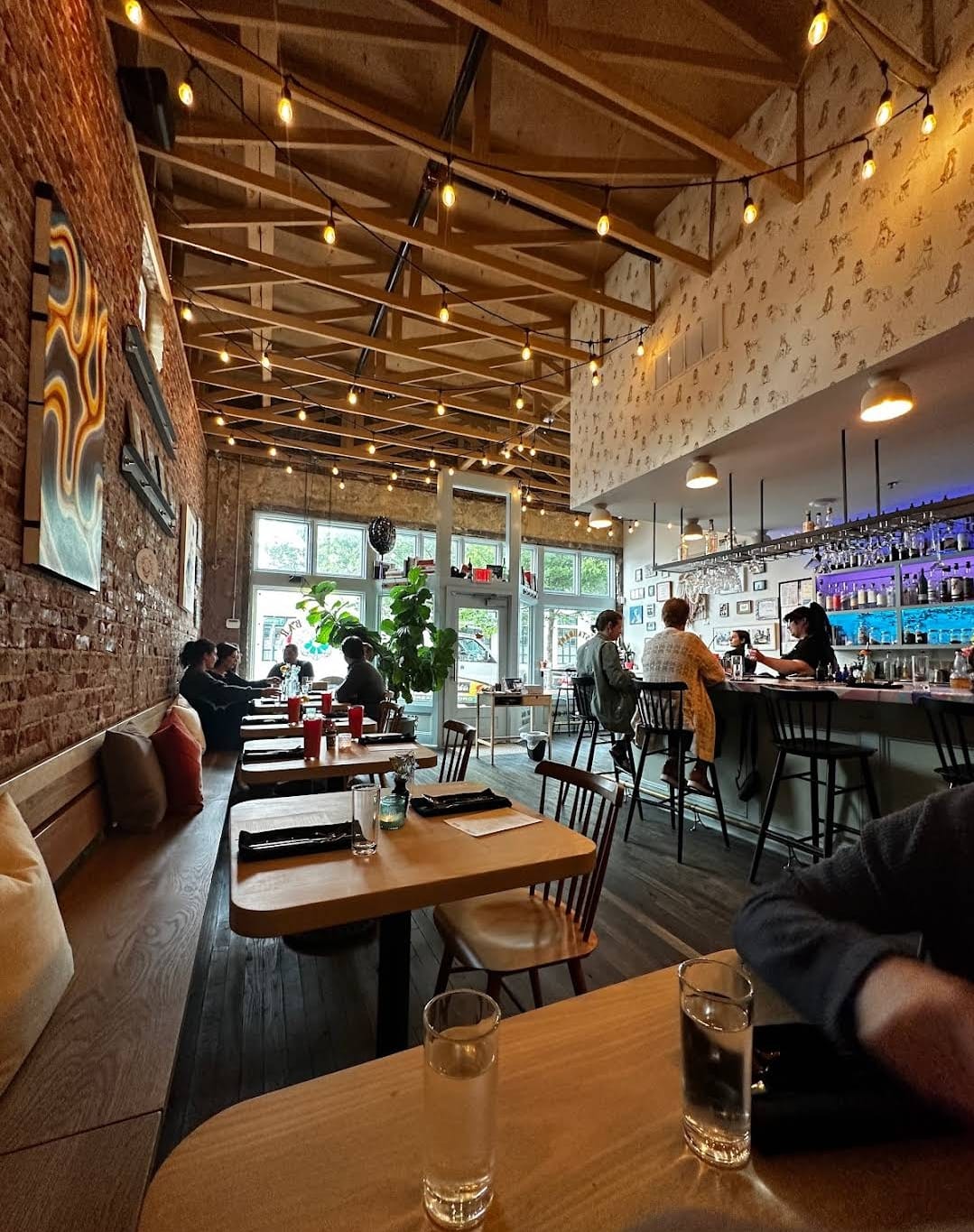 A modern restaurant interior with sleek furnishings and a captivating view of the bustling bar area, exuding contemporary elegance and urban sophistication