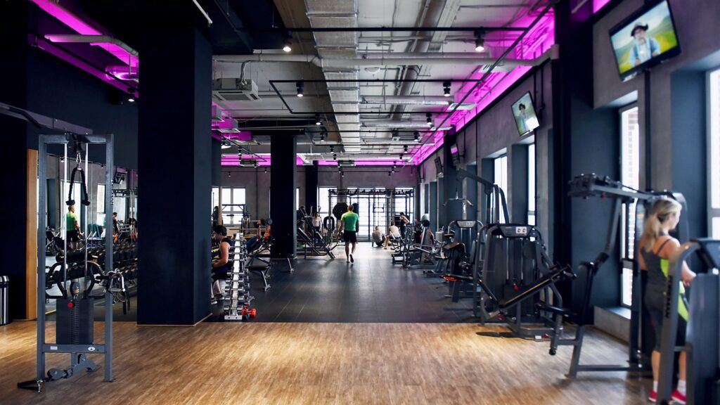 A highly advanced-looking gym with multiple exercise machines and free weights.