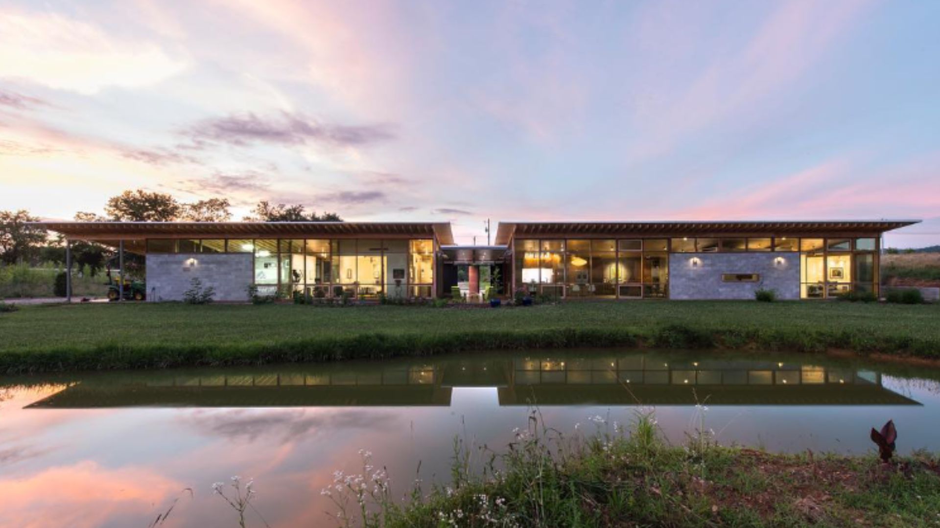 A stunning home featuring a backside entirely made of windows, offering breathtaking views of a tranquil lake