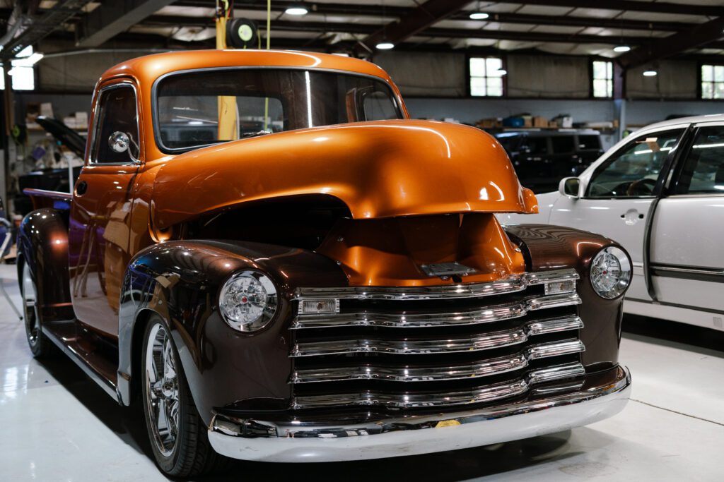Front profile of a retro orange truck with custom chrome detailing — blending nostalgia with bold upgrades.