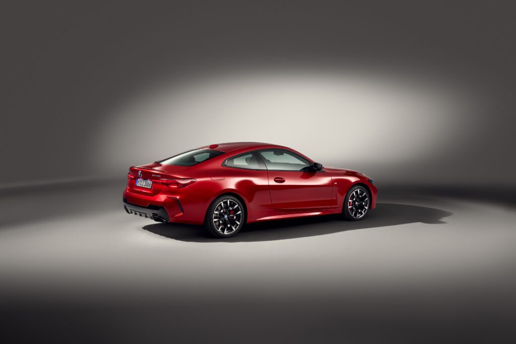 Side profile of the 2025 BMW M440i Coupe in red, highlighting its sporty silhouette and dynamic presence