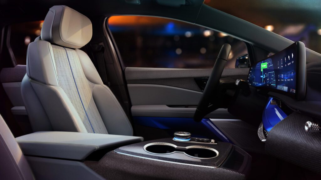 Driver’s side interior view, showcasing ambient lighting and ergonomic seat design with tech-forward display.