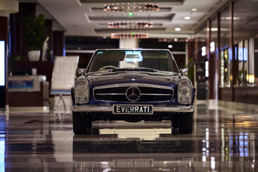 Front view of Everrati's black Mercedes-Benz Pagoda inside a luxury venue.