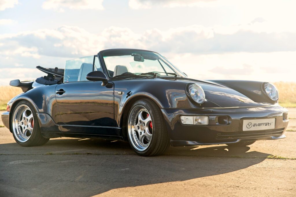 Black Everrati Porsche 911 Cabriolet parked outdoors under natural light.