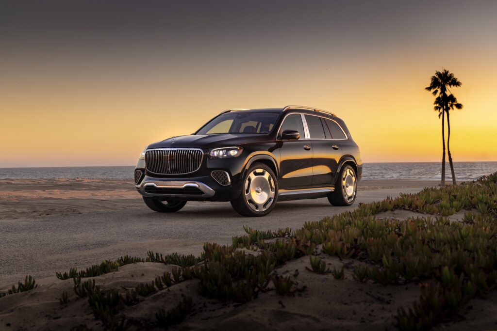 Front view of the 2025 Maybach GLS driving along the coast at sunset.